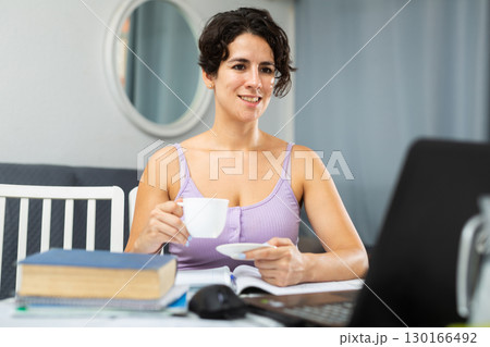 Woman surfing in Internet using laptop at home 130166492