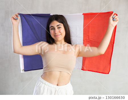Young woman with flag of France posing in studio Young woman with flag of France posing in studio 130166630