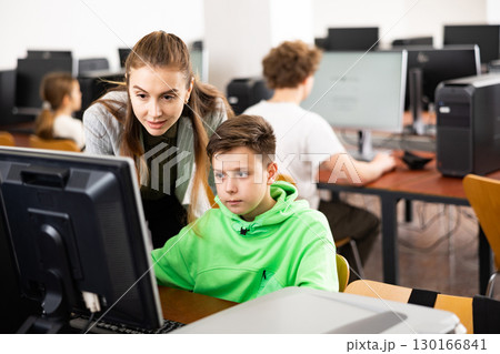 Teacher together with students conduct lesson on computer education 130166841