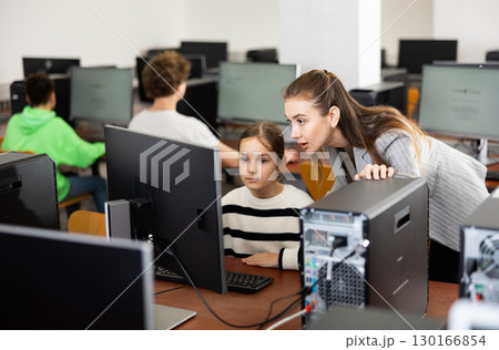 Teacher explaining task solution to pupil during computer science lesson Teacher explaining task solution to pupil during computer science lesson 130166854