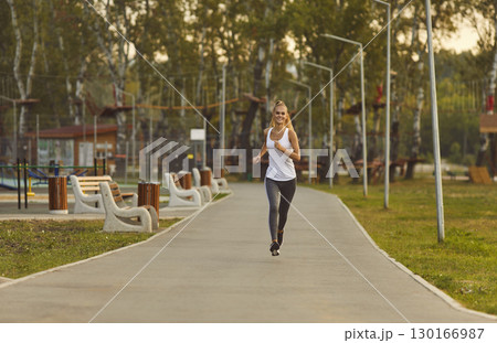 Woman Enjoying Outdoor Jogging in City Park Woman Enjoying Outdoor Jogging in City Park 130166987