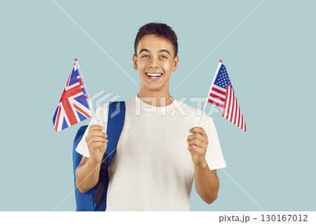 Happy smiling boy student learning English language holding American and British flags. 130167012