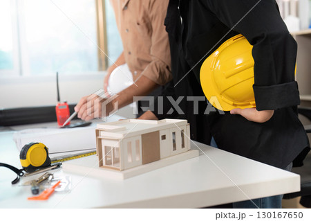 Construction Collaboration. Architect and engineer discussing building model at office. Construction Collaboration. Architect and engineer discussing building model at office. 130167650