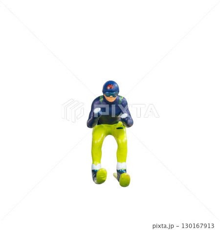 Miniature skier figure standing alone on white background with clean clipping path 130167913
