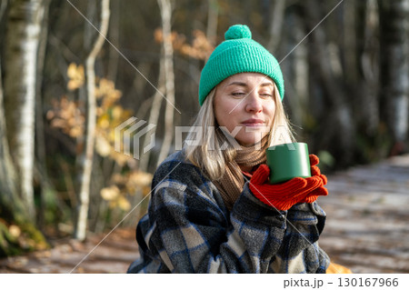 Time alone. Relaxed middle aged woman enjoy calm weekend in fall park meditative drinks thermos tea. Time alone. Relaxed middle aged woman enjoy calm weekend in fall park meditative drinks thermos tea. 130167966