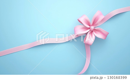pink flower ribbon tied knot on solid blue background 130168399
