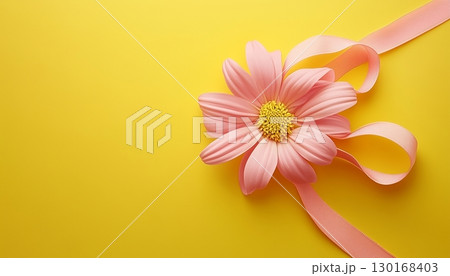 Pink flower ribbon tied knot on solid yellow background copy space romantic decoration 130168403