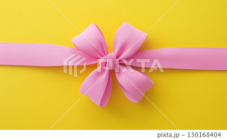 Pink flower ribbon tied knot on solid yellow background copy space romantic decoration 130168404