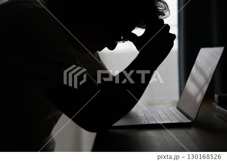 パソコンの前で悩む中年男性 130168526