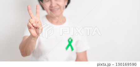 Elderly with Green Ribbon for concept of July Eye Injury Prevention month, January Glaucoma Awareness month, February Gallbladder and Bile duct and October Liver cancer. Health and world cancer day 130169590