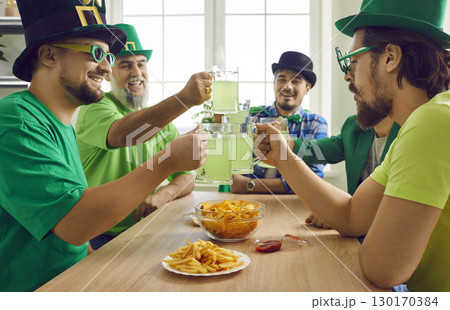 Happy close friends toasting with mugs of green beer at home 130170384