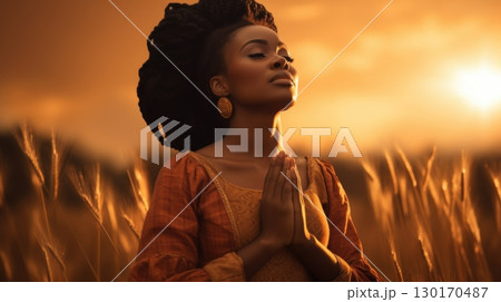 woman praying at sunset in wheat field 130170487