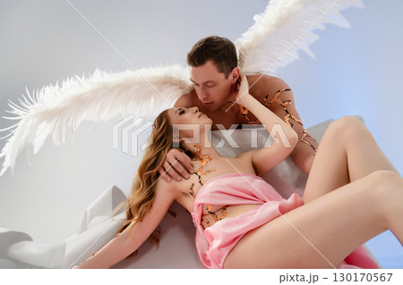 Romantic embrace between angelic figures in a dreamy setting with wings Romantic embrace between angelic figures in a dreamy setting with wings 130170567