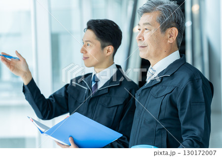 現場で打ち合わせする作業服のビジネスマン 130172007
