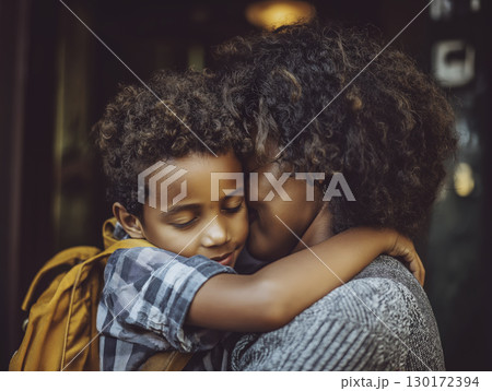 Mother hugs child with loving embrace on first day of school, sharing tender, emotional moment of connection and support 130172394