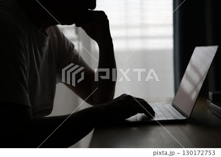 暗い部屋でパソコンを使う男性 暗い部屋でパソコンを使う男性 130172753