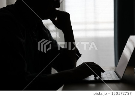 暗い部屋でパソコンを使う男性 暗い部屋でパソコンを使う男性 130172757