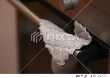 close-up image of a gray rag or towel for cleaning in a kitchen. home cleaning supplies rag. gray microfiber towel kitchen 130177437