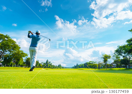 青空の下でショットを打つゴルファーの後ろ姿 青空の下でショットを打つゴルファーの後ろ姿 130177459