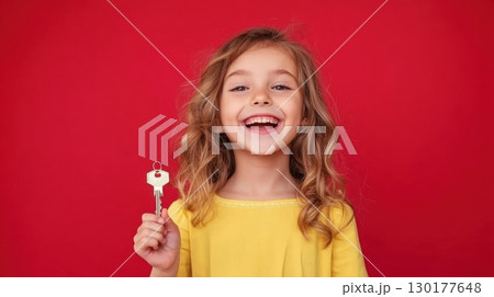 Happy Little Girl Holding a Key 130177648