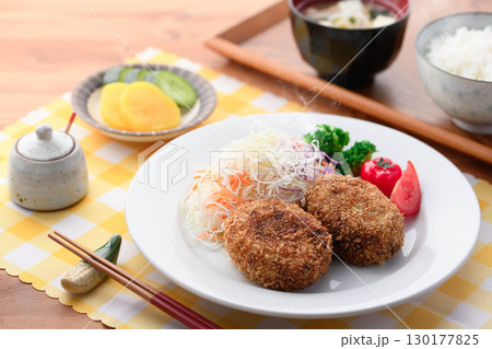 湯気が立ち上る揚げたてコロッケ定食 千切りキャベツとご飯味噌汁漬物付きの和食ランチ 湯気が立ち上る揚げたてコロッケ定食 千切りキャベツとご飯味噌汁漬物付きの和食ランチ 130177825