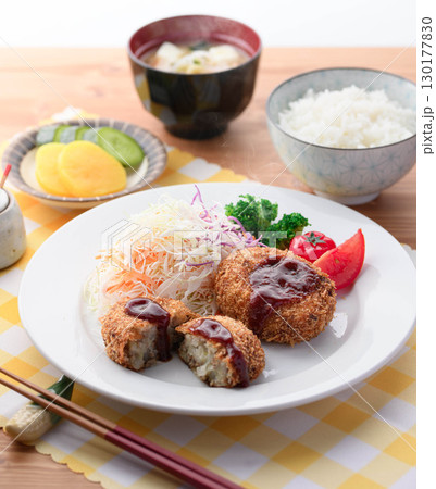 湯気が立ち上る揚げたてコロッケ定食　千切りキャベツとご飯味噌汁漬物付きの和食ランチ 130177830