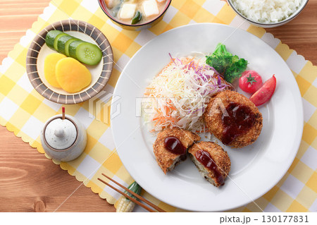 湯気が立ち上る揚げたてコロッケ定食　千切りキャベツとご飯味噌汁漬物付きの和食ランチ 130177831