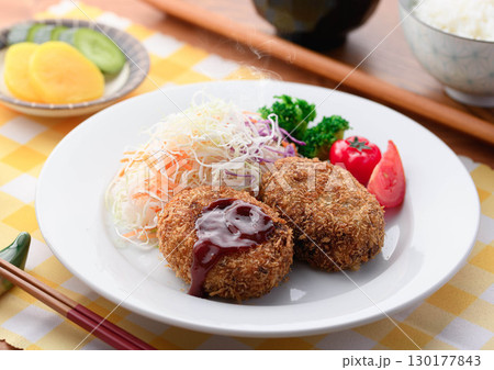 湯気が立ち上る揚げたてコロッケ定食 千切りキャベツとご飯味噌汁漬物付きの和食ランチ 湯気が立ち上る揚げたてコロッケ定食 千切りキャベツとご飯味噌汁漬物付きの和食ランチ 130177843