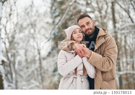 Cheerful facial expression. Lovely couple have a walk in the winter forest Cheerful facial expression. Lovely couple have a walk in the winter forest 130178013