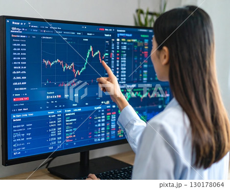 株価の推移を見つめ指さす若いビジネスパーソン　トレーダー　女性投資家 130178064