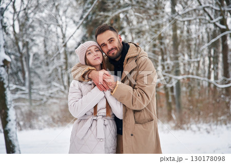 Cheerful facial expression. Lovely couple have a walk in the winter forest 130178098