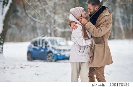 Lovely people. Happy couple having a walk in winter forest. Blue car is parked Lovely people. Happy couple having a walk in winter forest. Blue car is parked 130178125