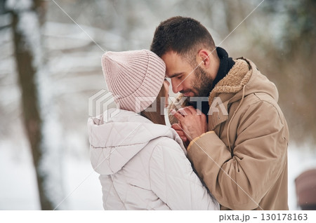 Lovely couple have a walk in the winter forest Lovely couple have a walk in the winter forest 130178163