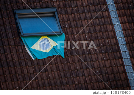Brazilian Flag Displayed on Rooftop Window on a tiled roof 130178400