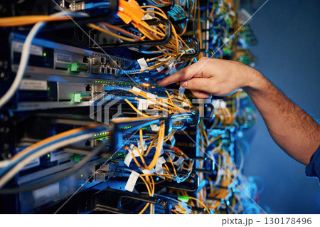 Cables management. Young man is working with internet equipment and wires in server room 130178496