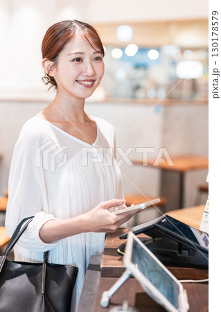 キャッシュレス　スマホ決済　若い女性 130178579