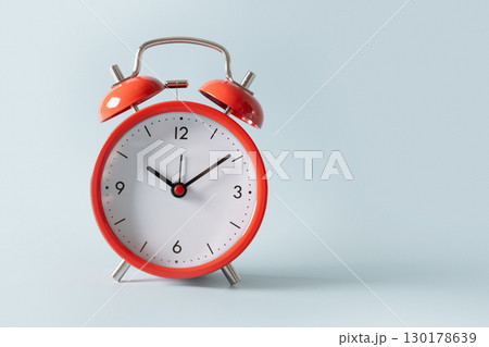 Red alarm clock on blue background. Red alarm clock on blue background. 130178639
