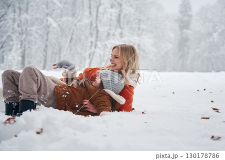 Playing and having fun. Mother and her daughter is on the winter meadow and forest 130178786