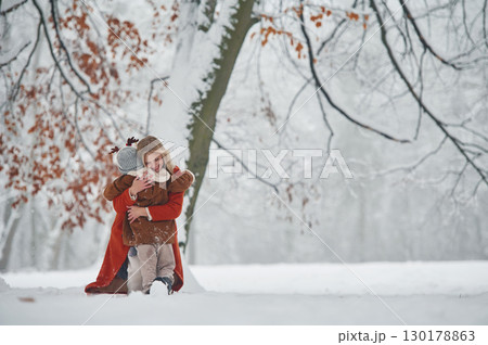 Embracing each other. Mother and her daughter is on the winter meadow and forest 130178863