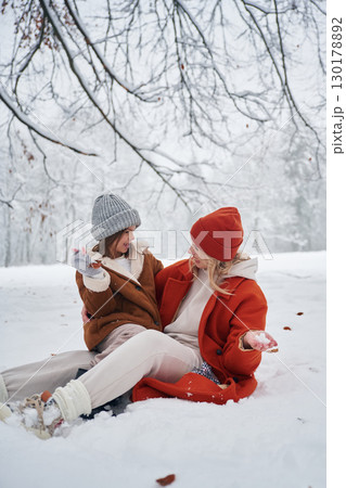 On the snow. Mother and her daughter is on the winter meadow and forest 130178892