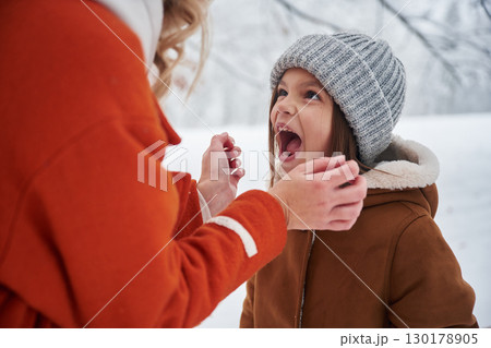 Girl is screaming. Mother and her daughter is on the winter meadow and forest 130178905
