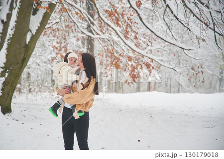 Woman with her little boy is in the winter forest on the meadow Woman with her little boy is in the winter forest on the meadow 130179018