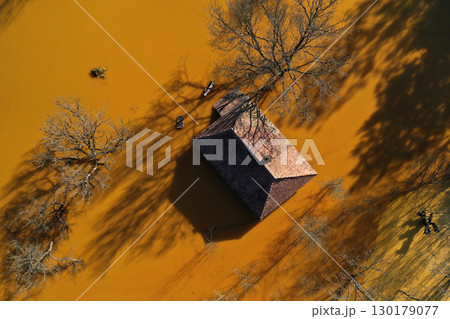 Aerial view of sinking village house in the middle of toxic mine decanting lake 130179077