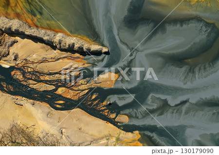 Flying over patterns of acid mine drainage in decanting lake aerial Flying over patterns of acid mine drainage in decanting lake aerial 130179090