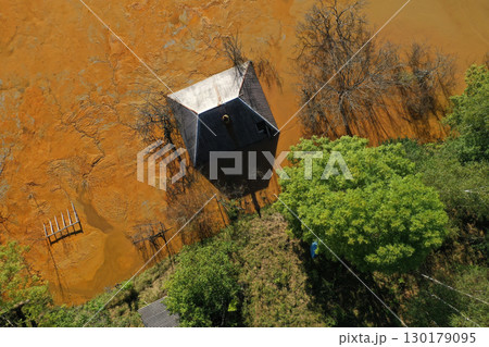 Aerial view of sinking village house in the middle of toxic acid mine drainage decanting pond. Geamana, Rosia Montana, Romania 130179095