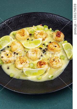 Seared scallop with lime in plate. 130179839