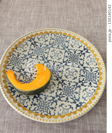 Pieces, slices of pumpkin on porcelain plate with blue pattern. Farm products and healthy eating. Kitchen and home cooking. Pieces, slices of pumpkin on porcelain plate with blue pattern. Farm products and healthy eating. Kitchen and home cooking. 130180142
