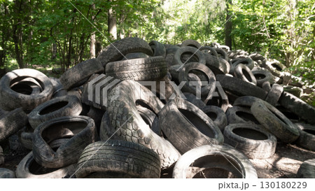 Abandoned tires are blending seamlessly into the forest background, raising significant environmental concerns Abandoned tires are blending seamlessly into the forest background, raising significant environmental concerns 130180229