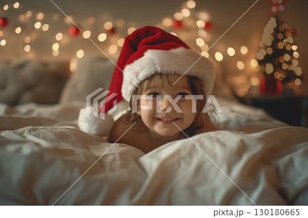 Adorable christmas child smiling in santa hat, captured at home 130180665