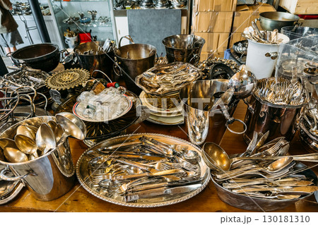 Assorted vintage silver cutlery and serving pieces arranged in trays and buckets at a resale market. Eco-friendly hosting, reusable dining tools, conscious entertaining, sustainable dinner parties Assorted vintage silver cutlery and serving pieces arranged in trays and buckets at a resale market. Eco-friendly hosting, reusable dining tools, conscious entertaining, sustainable dinner parties 130181310